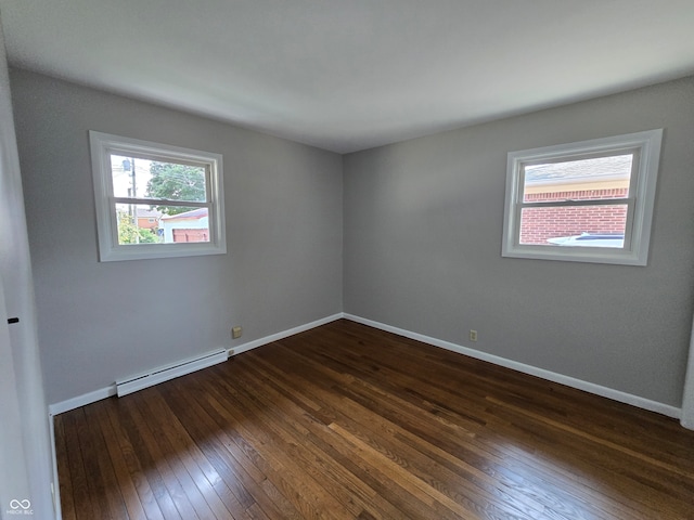 unfurnished room with dark hardwood / wood-style floors and baseboard heating