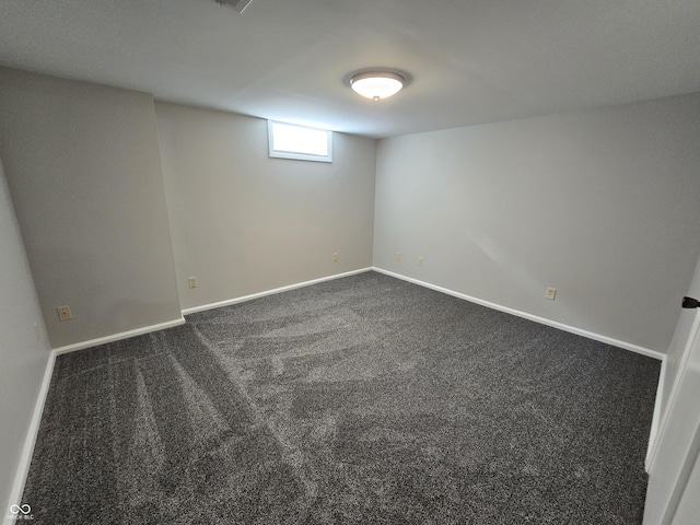 basement with dark colored carpet, visible vents, and baseboards