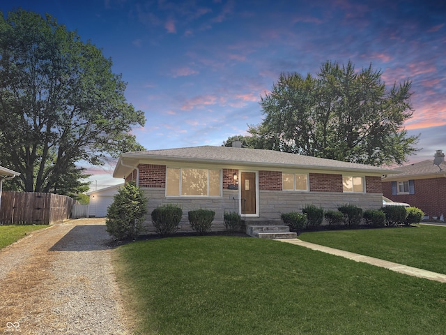 ranch-style home with stone siding, a chimney, gravel driveway, fence, and a yard