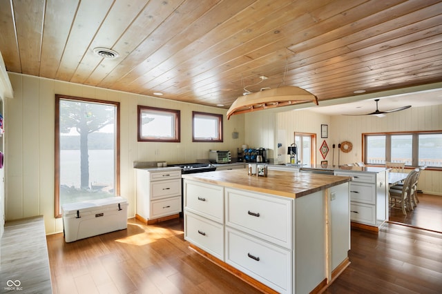 kitchen with hardwood / wood-style floors, a center island, plenty of natural light, and wooden ceiling