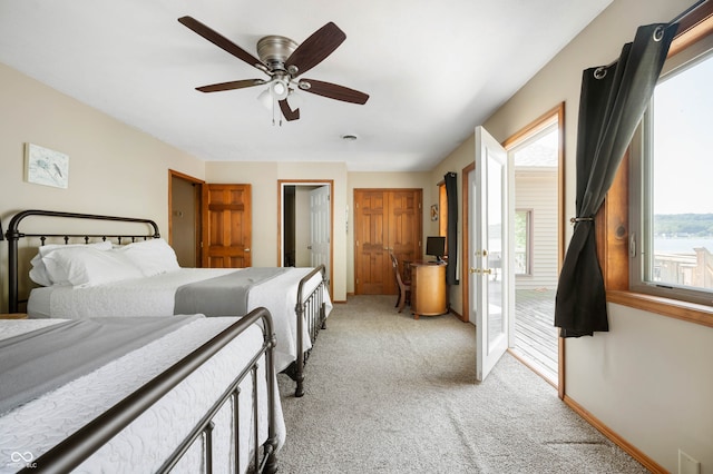 bedroom featuring ceiling fan, light colored carpet, and multiple windows