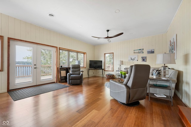 living room with ceiling fan, french doors, and light hardwood / wood-style floors