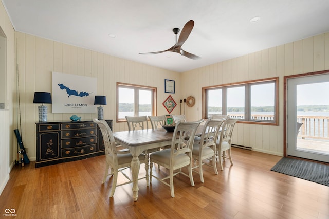 dining space with a water view, a wealth of natural light, light hardwood / wood-style flooring, and ceiling fan