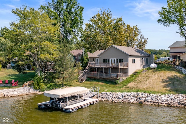 rear view of property with a yard and a deck with water view