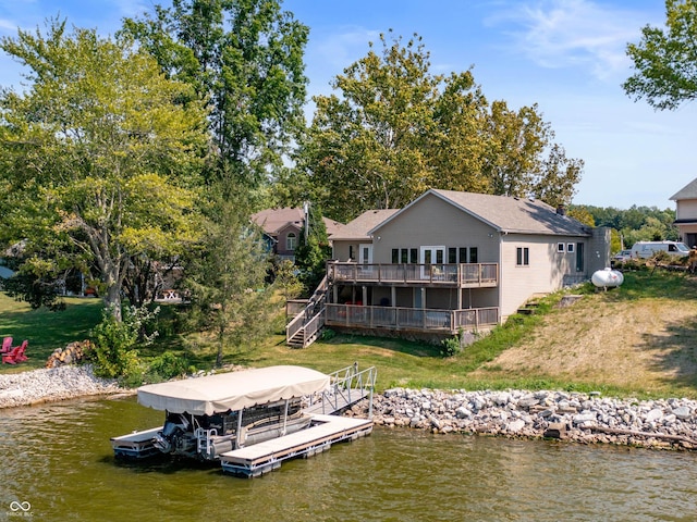 back of property featuring a lawn and a deck with water view