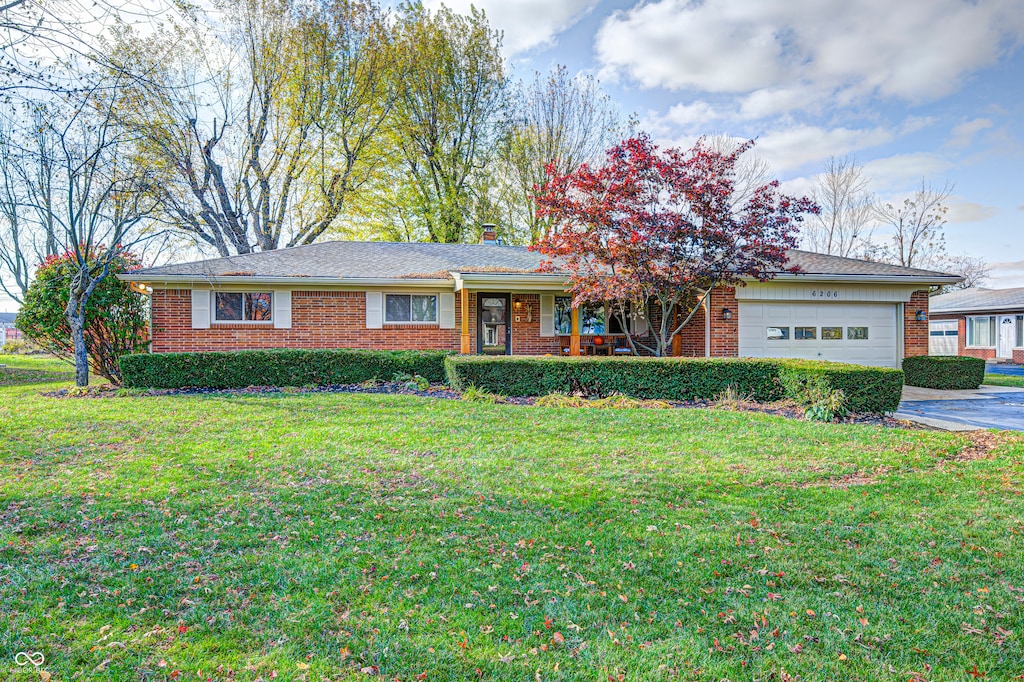 ranch-style house with a garage and a front yard