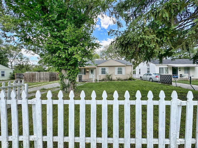 view of front of home featuring a fenced front yard and a front lawn