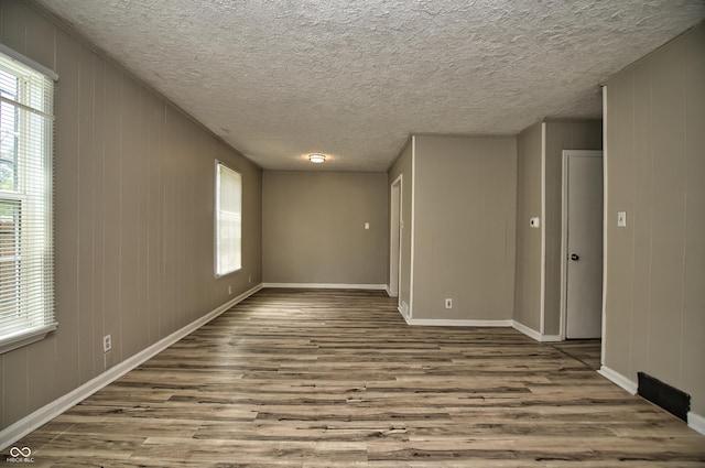 spare room with baseboards, a healthy amount of sunlight, and wood finished floors