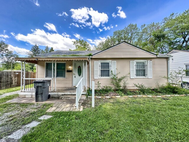 view of front of house with covered porch and a front lawn