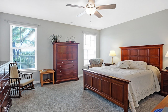 bedroom with light carpet, ceiling fan, baseboards, and multiple windows