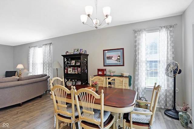 dining room with wood finished floors and an inviting chandelier