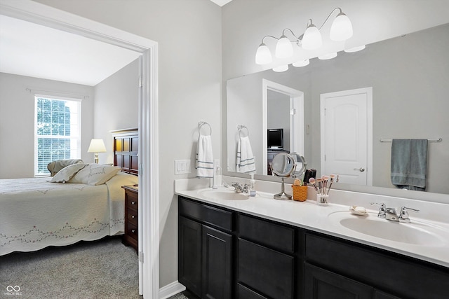 ensuite bathroom featuring double vanity, a sink, and connected bathroom