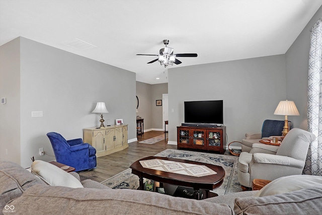 living room featuring wood finished floors, a ceiling fan, and baseboards