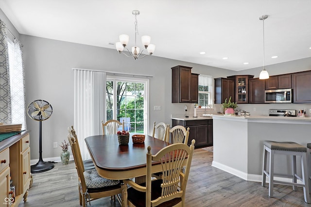 dining room featuring light wood-type flooring, an inviting chandelier, baseboards, and recessed lighting