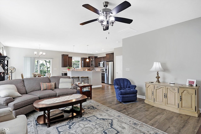 living room featuring recessed lighting, visible vents, wood finished floors, baseboards, and ceiling fan with notable chandelier