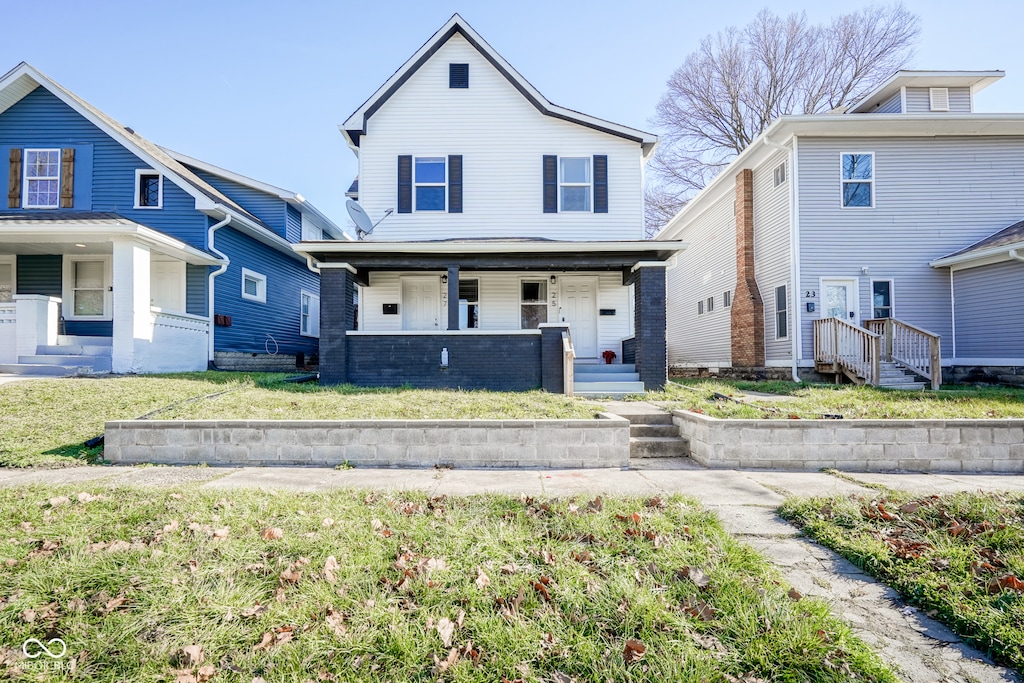 view of property featuring a front lawn and covered porch