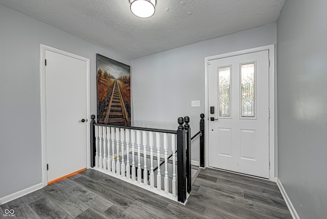 entrance foyer with dark wood-type flooring and a textured ceiling