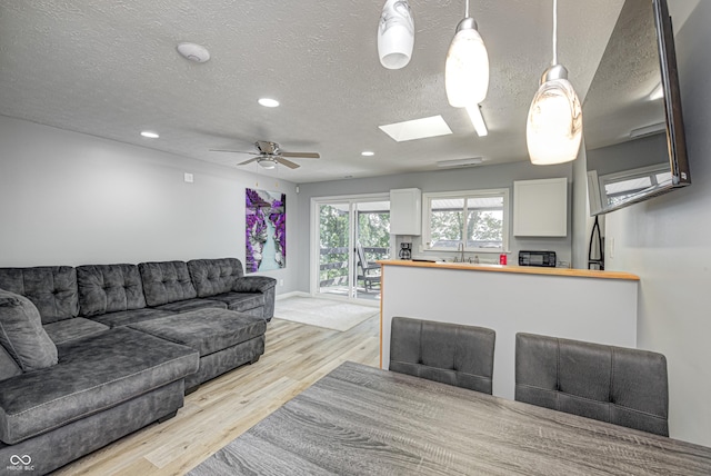 7587 Shady Side Dr, Bloomington, IN 47401 - living room with a textured ceiling, a skylight, light wood finished floors, recessed lighting, and a ceiling fan
