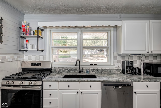 kitchen with a healthy amount of sunlight, sink, appliances with stainless steel finishes, and white cabinetry