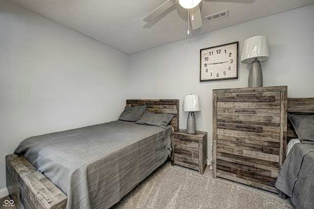 carpeted bedroom with a textured ceiling and ceiling fan