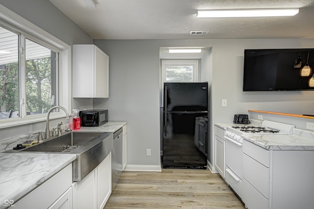 7587 Shady Side Dr, Bloomington, IN 47401 - kitchen with white gas range oven, a sink, freestanding refrigerator, dishwasher, and light wood-style floors