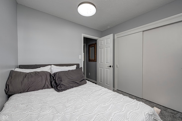 bedroom with a closet, a textured ceiling, and carpet flooring