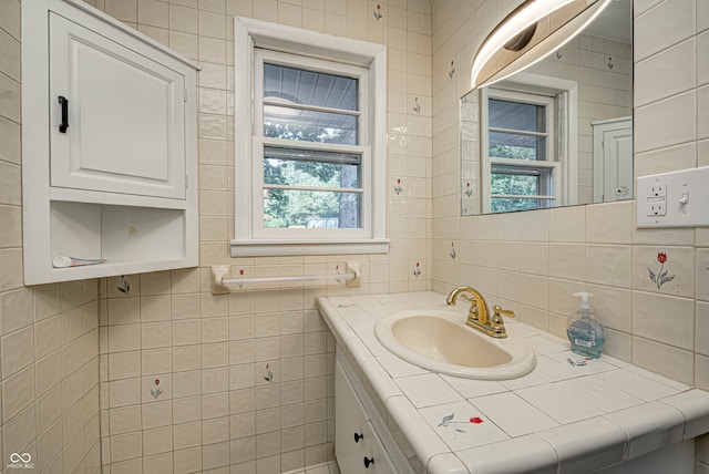 bathroom with tile walls, a wealth of natural light, and vanity