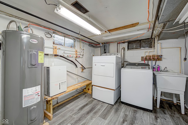 laundry room with light wood-type flooring, separate washer and dryer, sink, and electric water heater