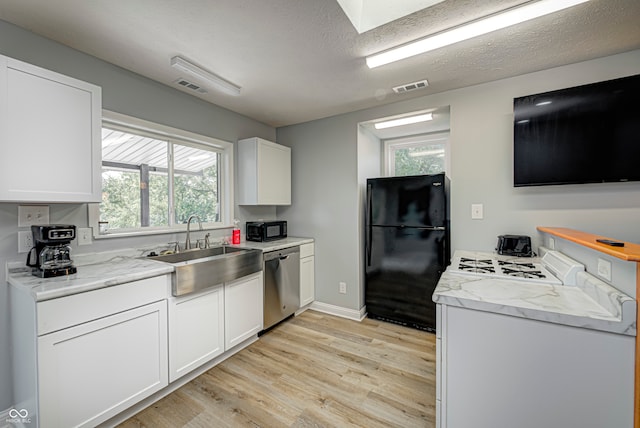 kitchen with plenty of natural light, black appliances, light hardwood / wood-style flooring, and white cabinets