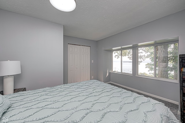 carpeted bedroom featuring a closet and a textured ceiling