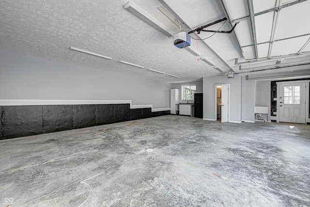 7587 Shady Side Dr, Bloomington, IN 47401 - garage featuring a garage door opener and freestanding refrigerator