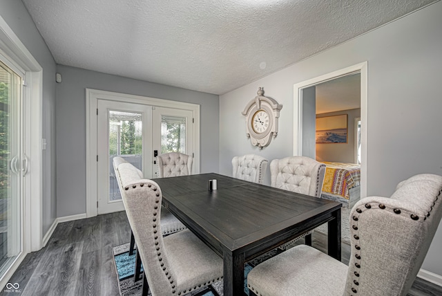 dining space with a textured ceiling, a healthy amount of sunlight, and dark wood-type flooring