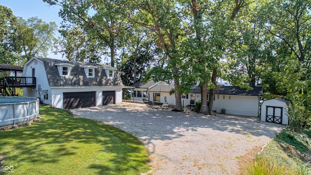 view of front of house with a garage, a storage shed, and a front lawn