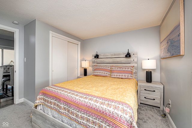 carpeted bedroom with a textured ceiling and a closet