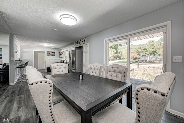 dining room featuring a textured ceiling and dark hardwood / wood-style floors