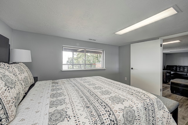 bedroom featuring a textured ceiling, wood-type flooring, and a closet