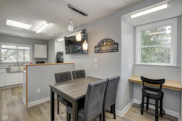 7587 Shady Side Dr, Bloomington, IN 47401 - dining room featuring a textured ceiling, a healthy amount of sunlight, and light wood finished floors