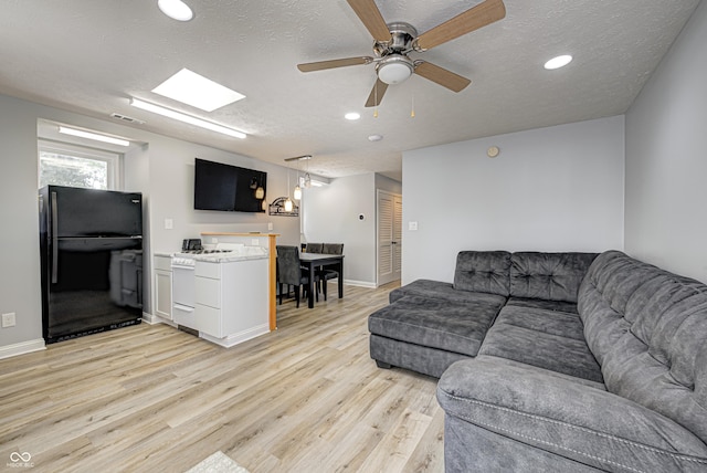 7587 Shady Side Dr, Bloomington, IN 47401 - living room with baseboards, a textured ceiling, light wood-style floors, visible vents, and ceiling fan