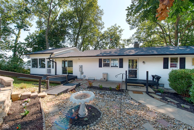 single story home featuring a patio and a wooden deck