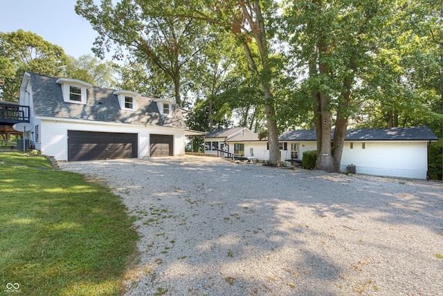 7587 Shady Side Dr, Bloomington, IN 47401 - view of front of house featuring a detached garage, driveway, a shingled roof, and a front lawn