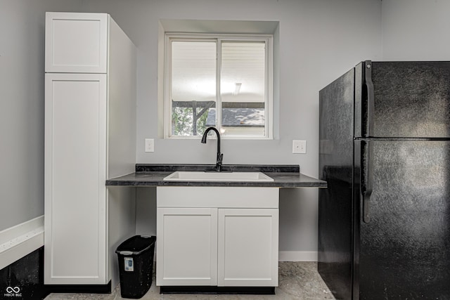 7587 Shady Side Dr, Bloomington, IN 47401 - kitchen featuring white cabinetry, a sink, and freestanding refrigerator