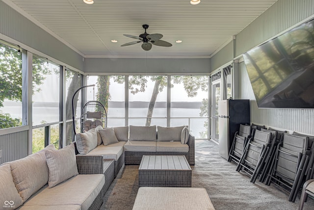 sunroom / solarium featuring a water view and ceiling fan