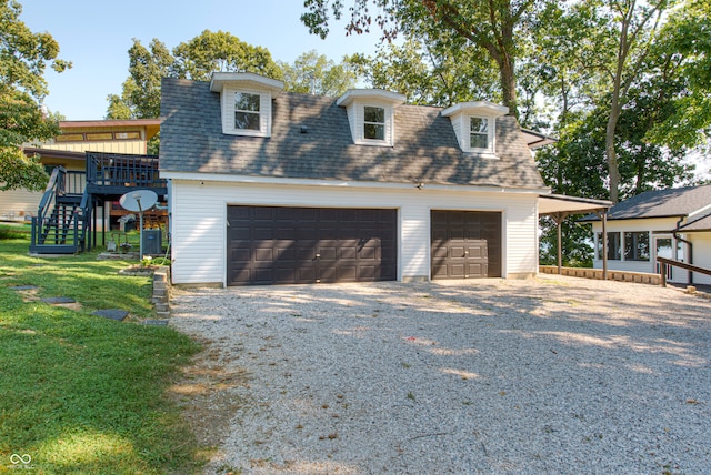 view of front of property featuring a wooden deck, a garage, and a front lawn