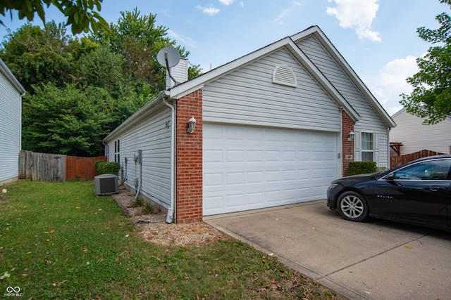 view of side of property with a garage, a lawn, and cooling unit