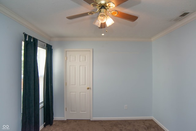 carpeted spare room with ceiling fan and ornamental molding