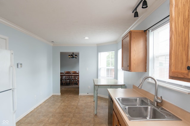 kitchen featuring white refrigerator, plenty of natural light, crown molding, and sink