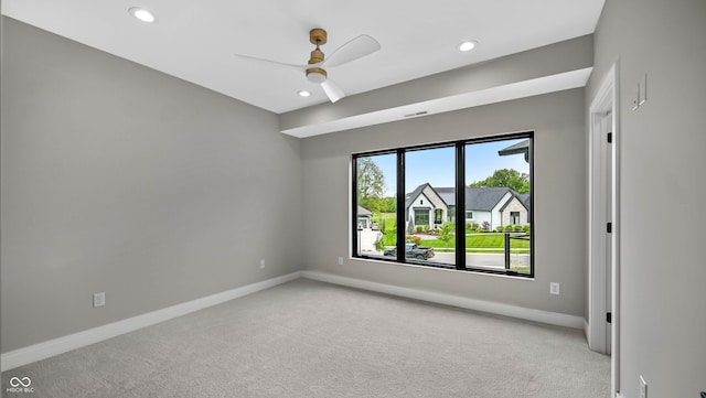 spare room with baseboards, recessed lighting, and light colored carpet