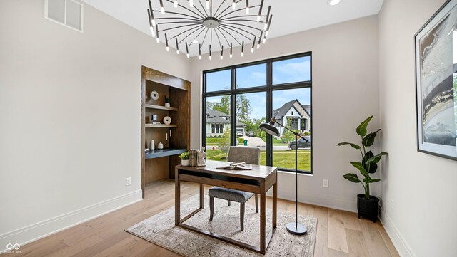 office with a chandelier and light wood-type flooring