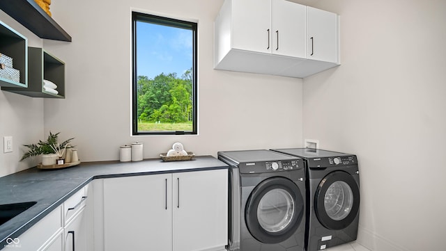 laundry area featuring cabinet space, independent washer and dryer, and a sink