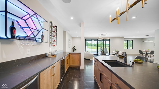 kitchen with recessed lighting, a sink, open floor plan, marble finish floor, and dark countertops